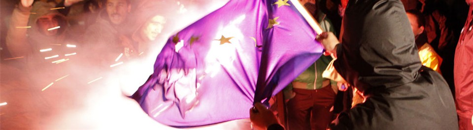 A Protester in Cyprus burns the flag of Europe