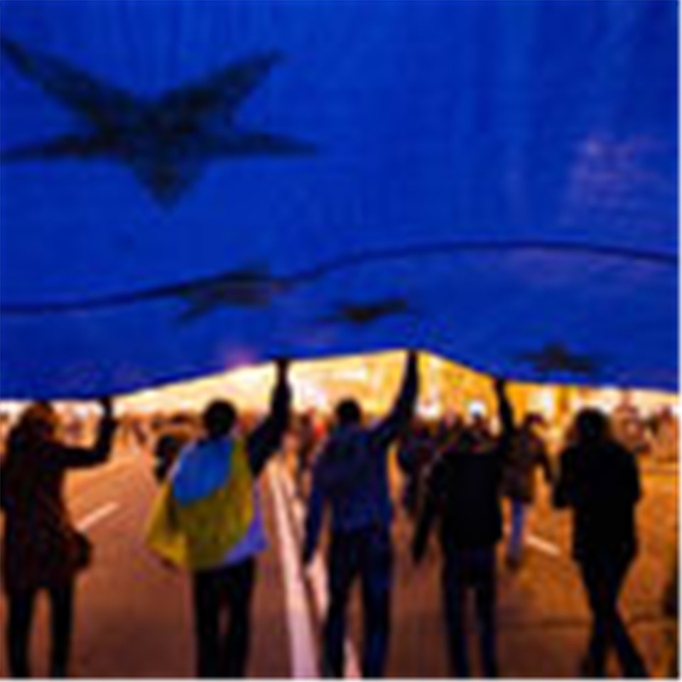 Uproar in the European neighborhood. Protesters in Kiev carry a European flag.