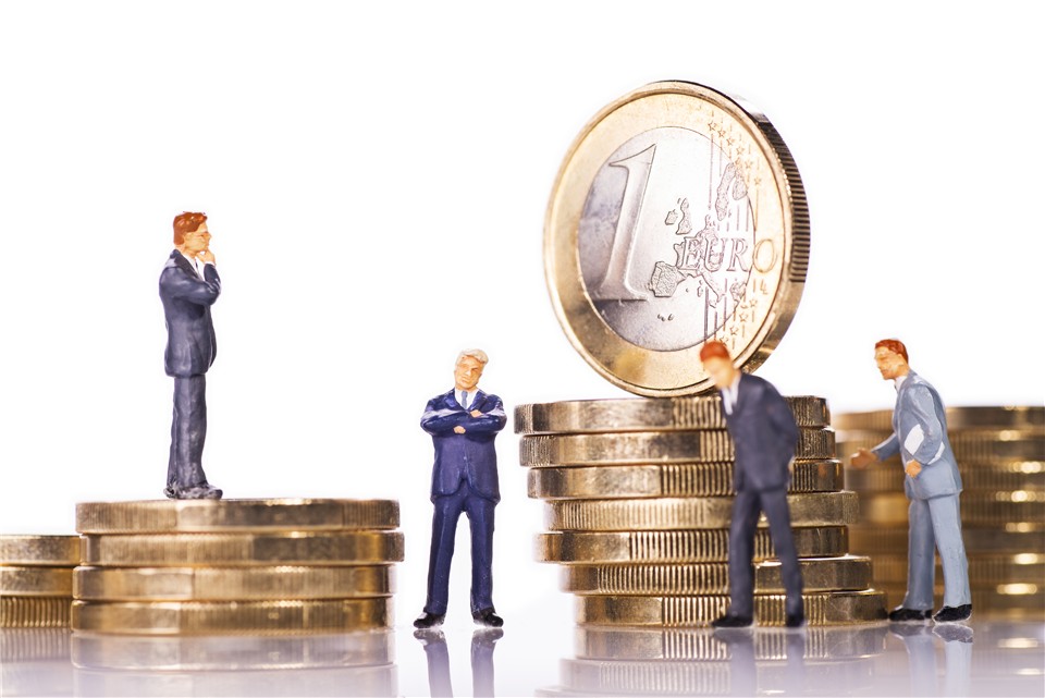 Modellfiguren von Geschäftsleuten mit Euromünzen.
