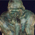 Abguss der Skulptur "Der Denker" des französischen Bildhauers Rodin vor dem angestrahlten Brandenburger Tor.