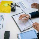 Team reviewing financial charts and digital data on tablets in an office setting., tags: über dem - pexel